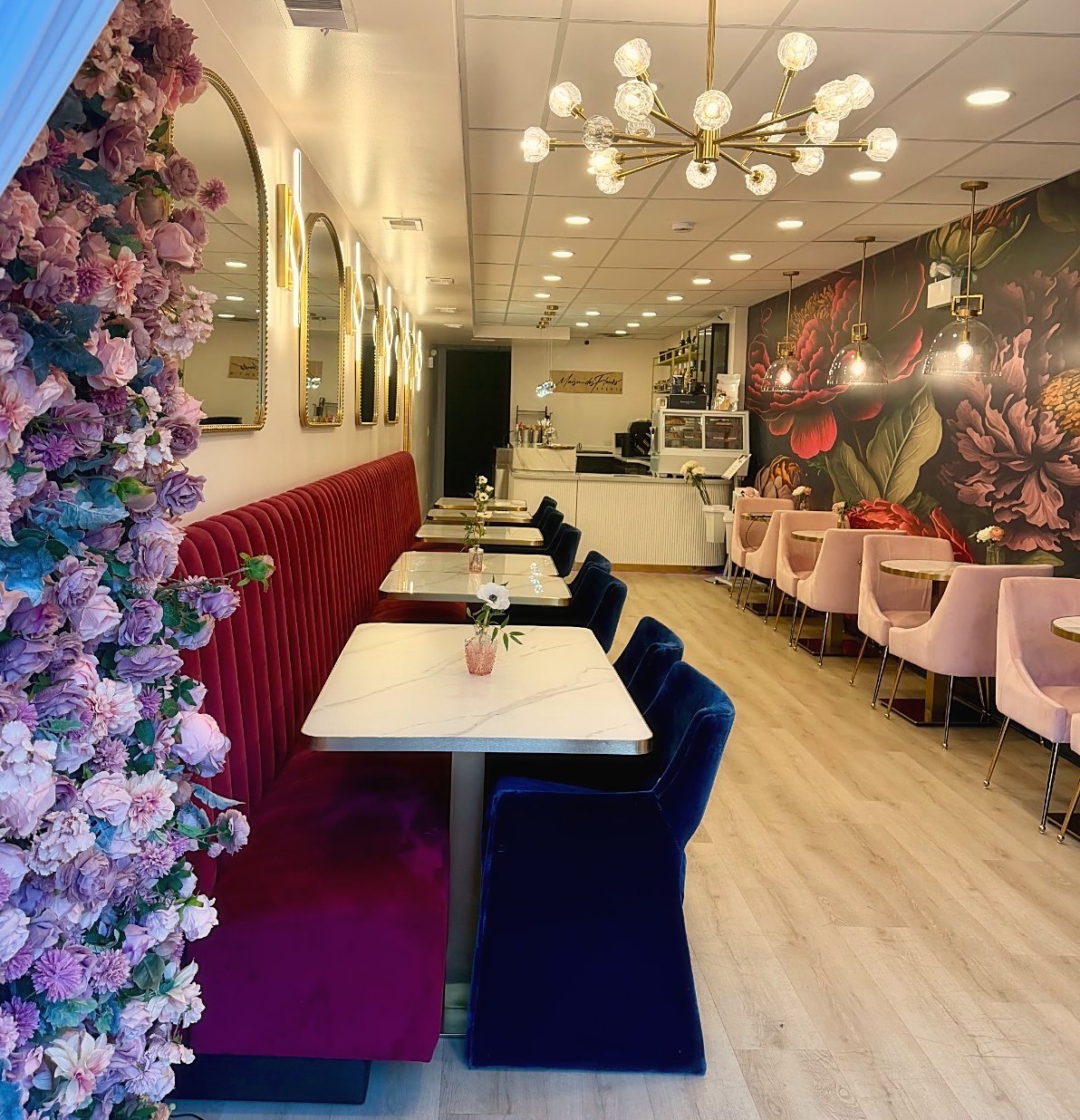 The Parlour interior with floral wall, velvet seating, and chandelier